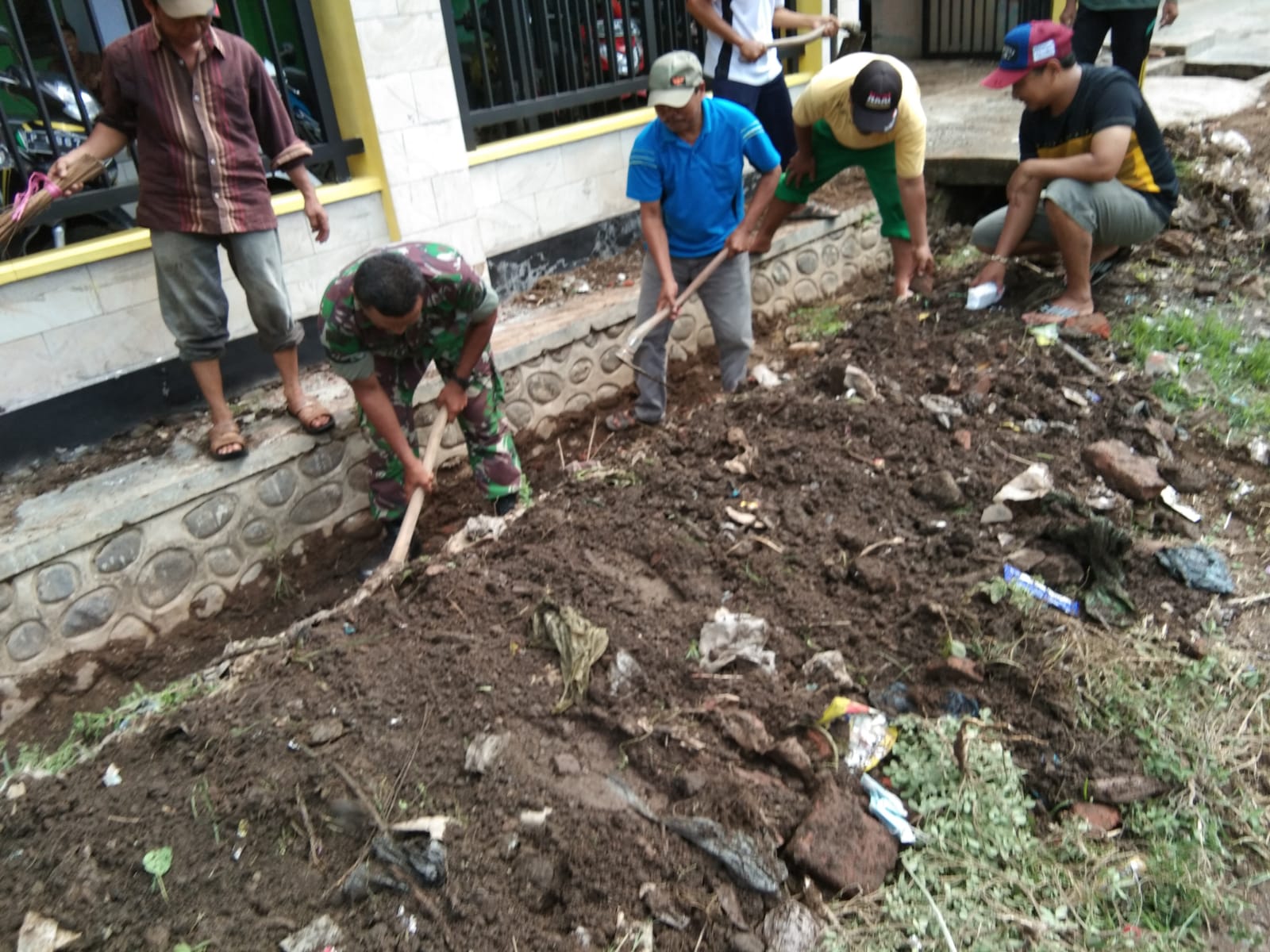 Sertu Pujiono Bantu Perangkat Desa Kerja Bakti Bersihkan Kantor Desa Bercak