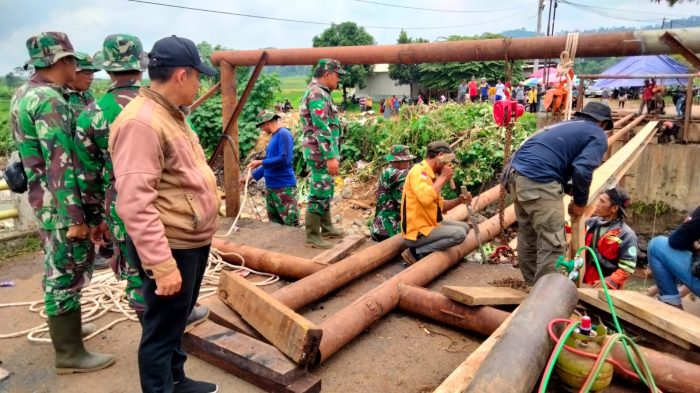 Babinsa Koramil 06/Tersono Bantu Perbaiki Jembatan Kalibelo Yang Rusak Akibat Banjir Bandang