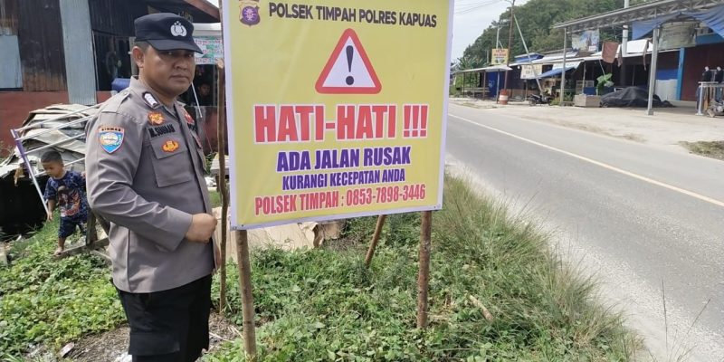 MINIMALISIR KECELAKAAN LALU LINTAS, PERSONEL POLSEK TIMPAH PASANG SPANDUK DAERAH RAWAN KECELAKAAN.