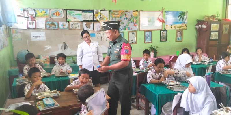 Peduli Anak Sekolah,Babinsa Dampingi Pelayanan Makan Bergizi Gratis